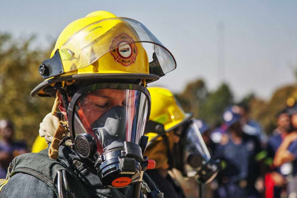Close-up firefighter in yellow helmet wearing full face breathing apparatus at emergency rescue competition