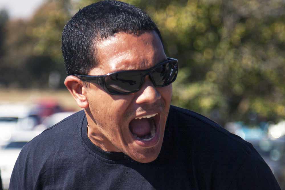 Male spectator in sunglasses cheering enthusiastically at SAESI firefighter competition
