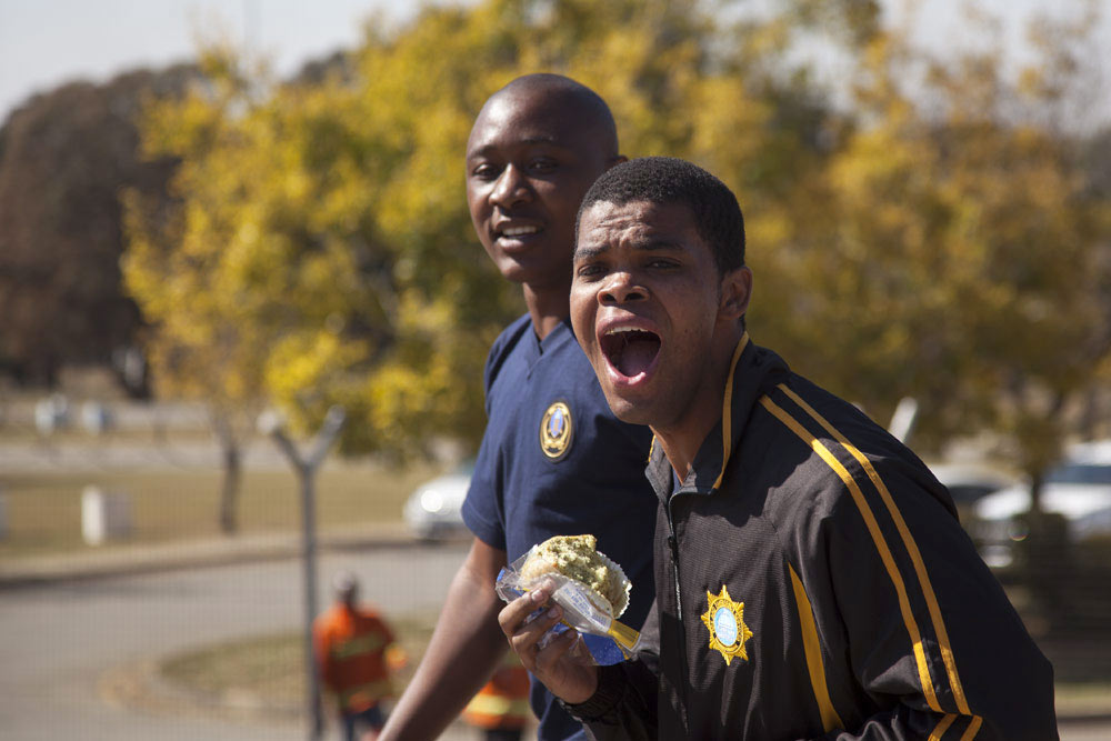 Two enthusiastic spectators cheering loudly at firefighter competition