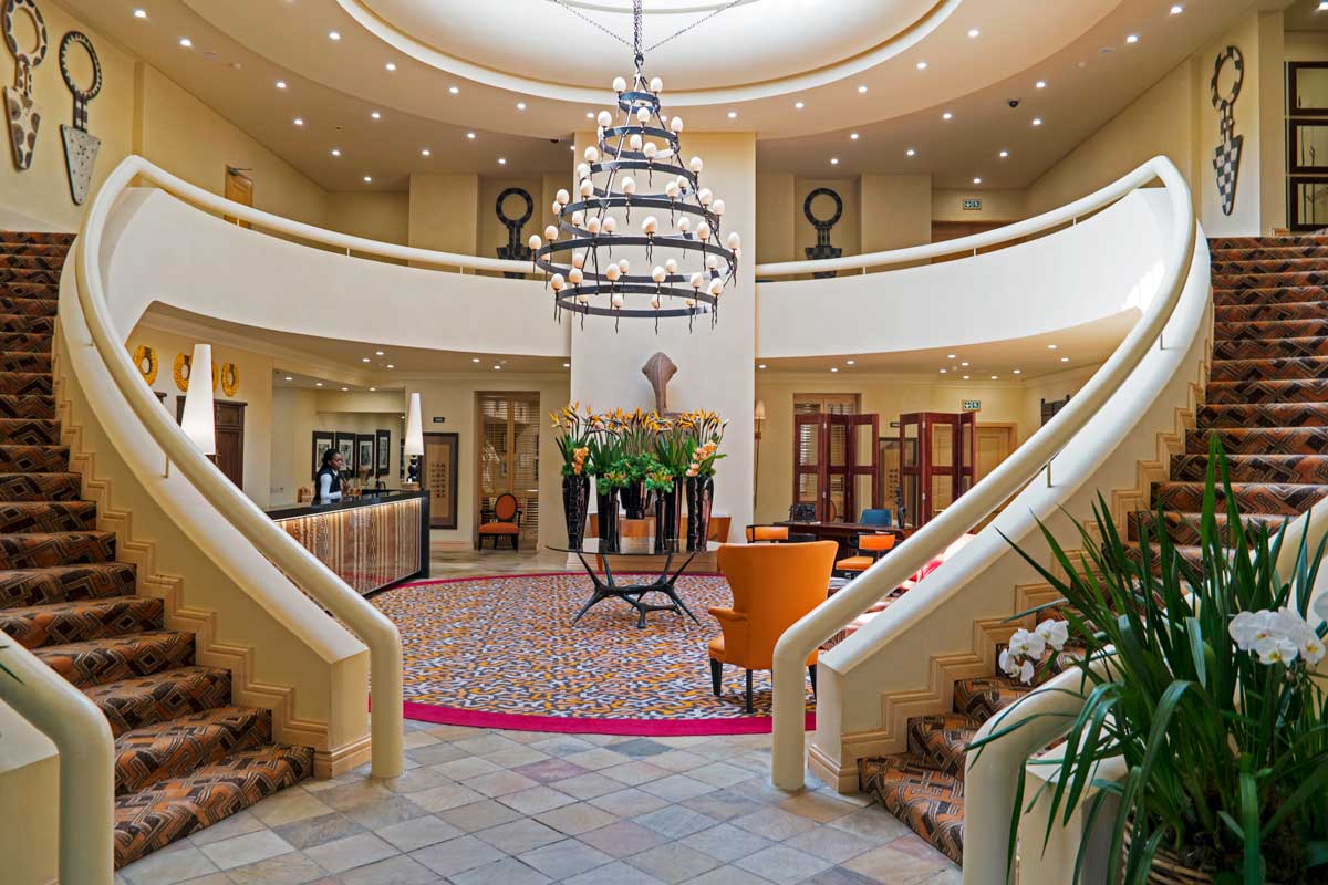 Grand hotel lobby with curved staircase and chandelier in Sandton Johannesburg luxury accommodation